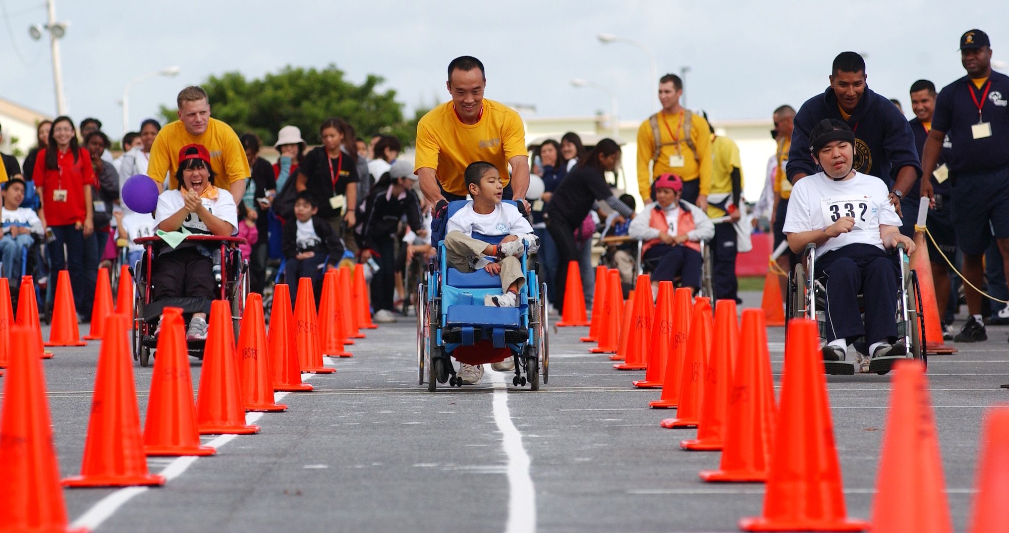 Military volunteers push special needs individuals in wheel chairs to the finish line during a wheel chair event Nov. 14, 2009 at Kadena Air Base, Japan. Kadena hosted the 10th Annual Special Olympic Games and Art Festival for special needs Okinawan and American adult and child athletes.  (U.S. Air Force photo/Tech. Sgt. Reynaldo Ramon) 
