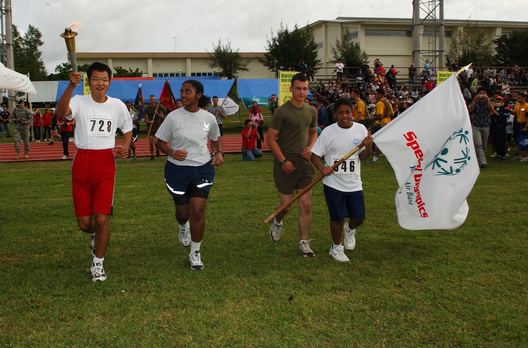 Military members escort an athlete as he walks with the Olympic torch during the opening ceremonies of the Kadena Special Olympics, held Nov. 14 at Kadena Air Base, Japan. This was the 10th anniversary of the KSO, a sporting event dedicated to enriching the lives of special needs individuals.
(U.S. Air Force photo/Tech. Sgt. Reynaldo Ramon)