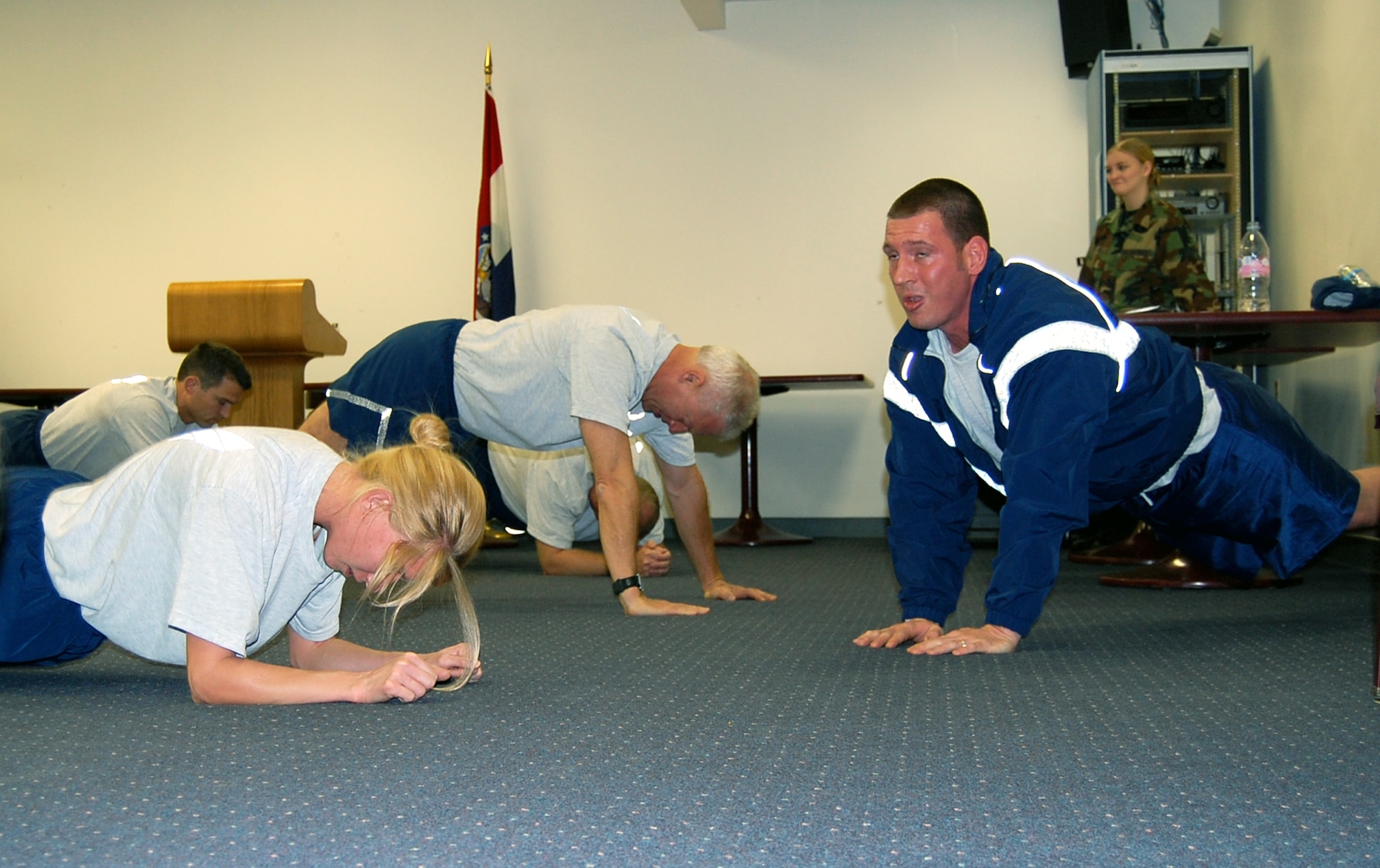 Staff Sgt. Matthew Storm, 131st Medical Group public health technition and PT leader, leads the members of the 131st MDG in self-paced 'plank pop-ups.' With the new fitness standards coming with the new year, the Medical Group knows the importance of staying fit even during the winter months. (Photo by Senior Airman Jessica Donnelly)