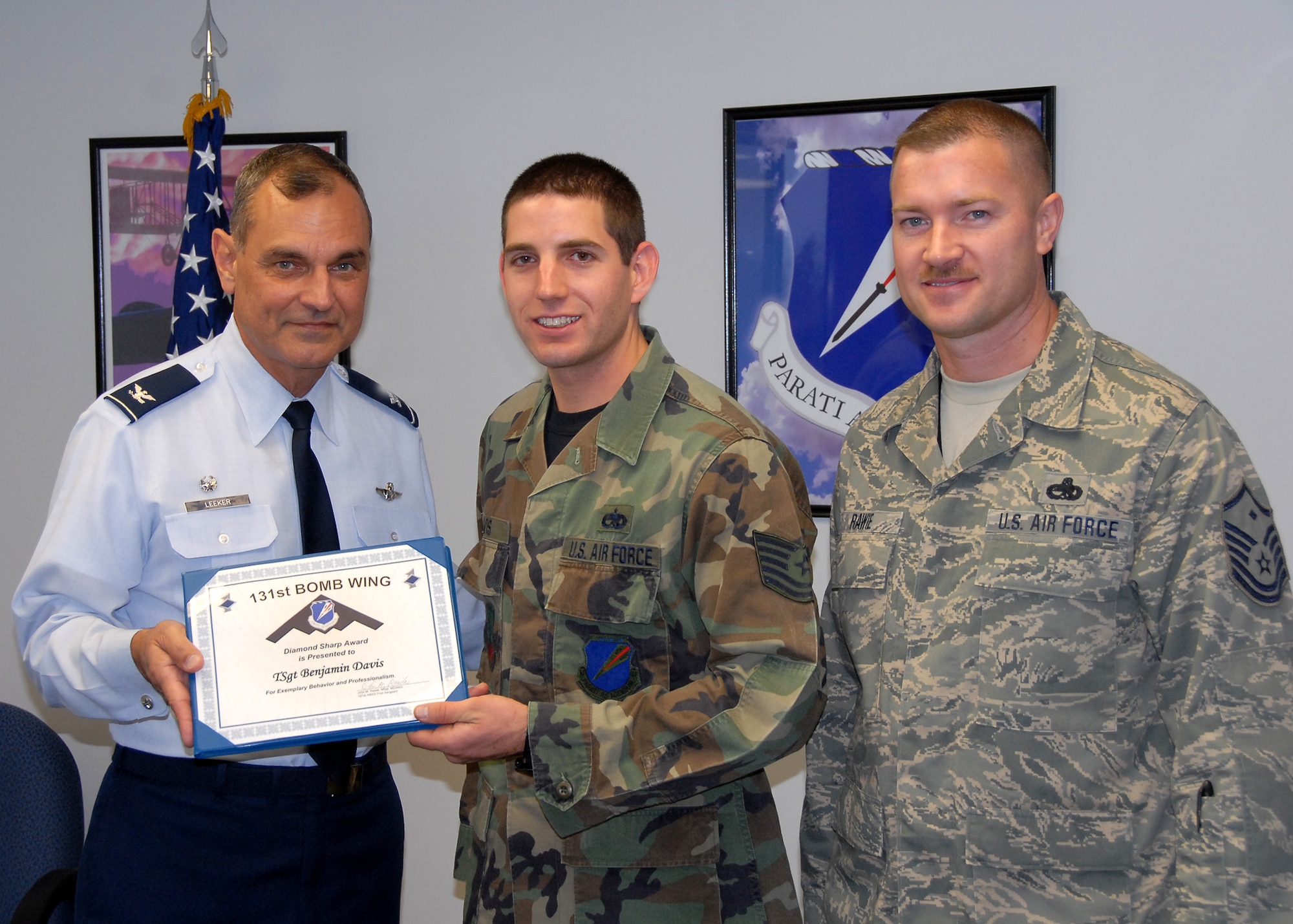 Col. Robert Leeker, 131st Bomb Wing commander, presents Tech. Sgt. Benjamin Davis, 131st Aircraft Maintenance Squadron aerospace maintenance technician, the Diamond Sharp Award for November UTA. (Photo by Master Sgt. Mary-Dale Amison)