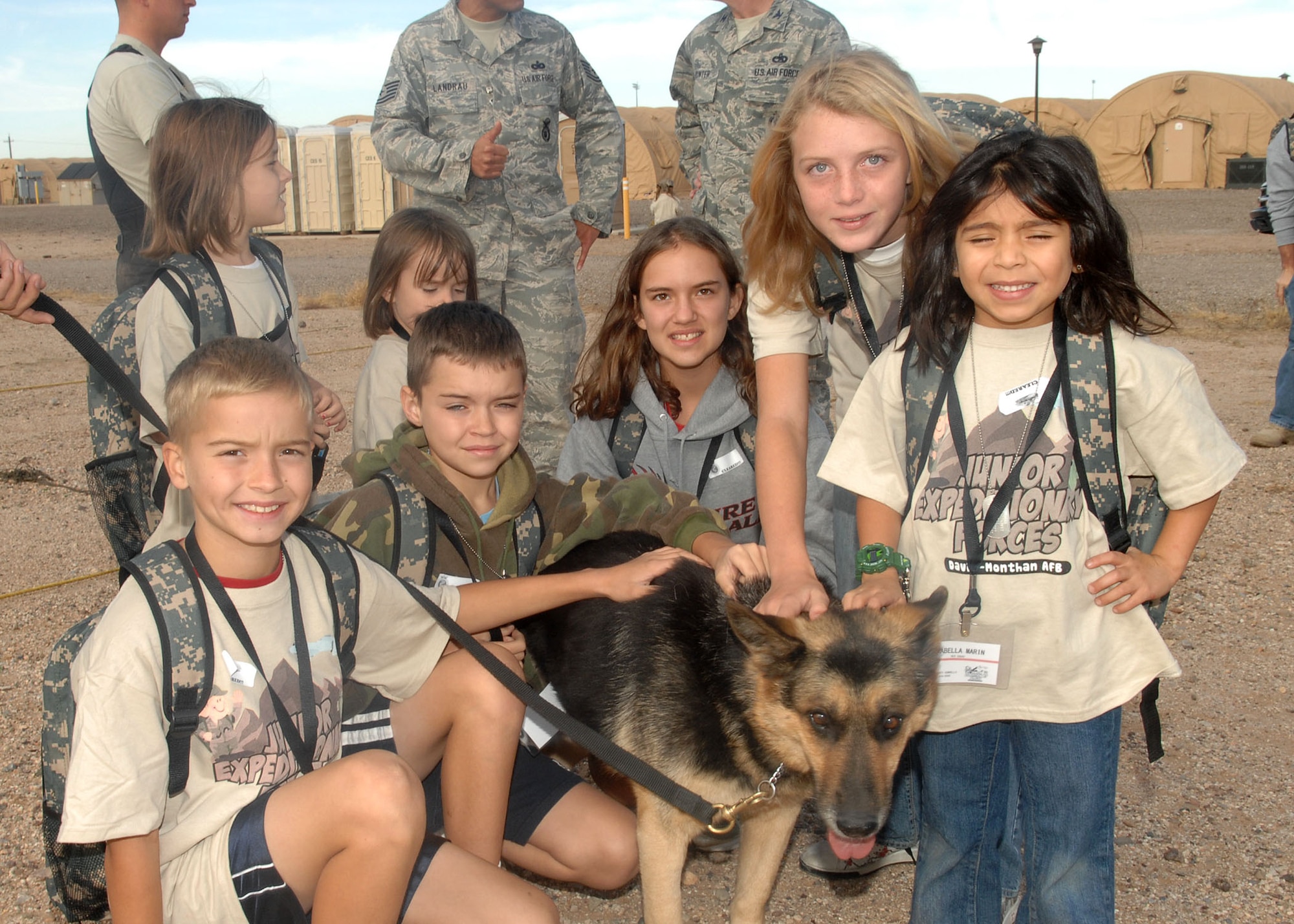 Children play with a security forces dog at the Desert Lightening Tent City as part of the Junior Expeditionary Forces event here, Nov. 7. More than 200 children participated and the event was supported by more than 100 base and local community volunteers. (U.S. Air Force photo/Airman Jerilyn Quintanilla)


