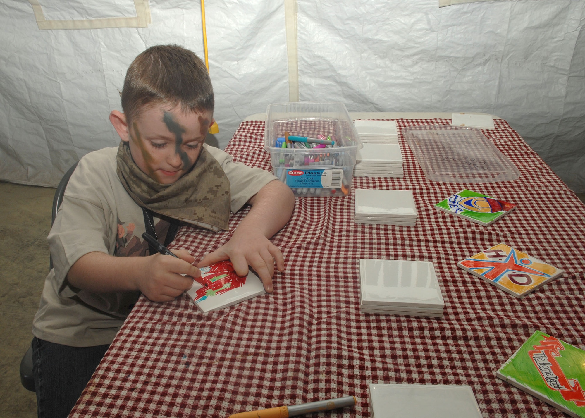 Fred Champlain, 6, son of Staff Sgt. Fred Champlain, 355th Logistics Readiness Squadron, paints at the arts and crafts tent sponsored by Home Depot, while participating in the Junior Expeditionary Forces here, Nov. 7. More than 200 children participated in this event which provided children of military members a chance to understand the deployment process. (U.S. Air Force photo/Airman Jerilyn Quintanilla)
