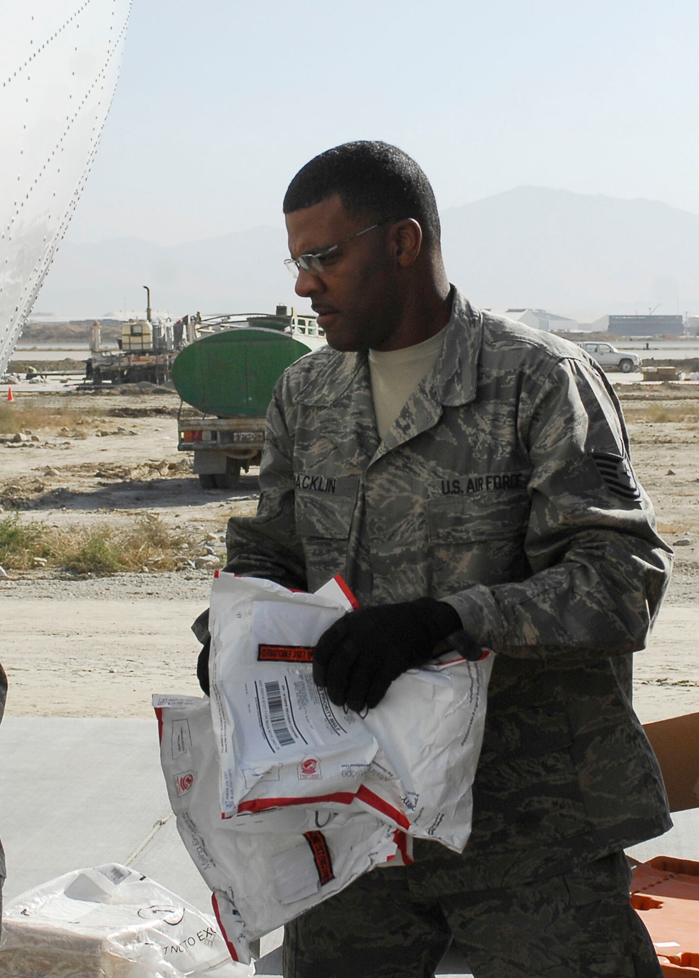 BAGRAM AIRFIELD, Afghanistan -- Tech. Sgt. Johnnie Macklin, an air transportation craftsman from the short take off and landing office of the 455th Expeditionary Aerial Port Squadron, loads mail onto an aircraft Nov. 15, 2009.  The STOL office is in charge of delivering personnel and mail to different forward operating bases.   Sergeant Macklin, a native of Atlanta, is deployed from Keesler Air Force Base, Miss.  (U.S. Air Force photo/Senior Airman Felicia Juenke)