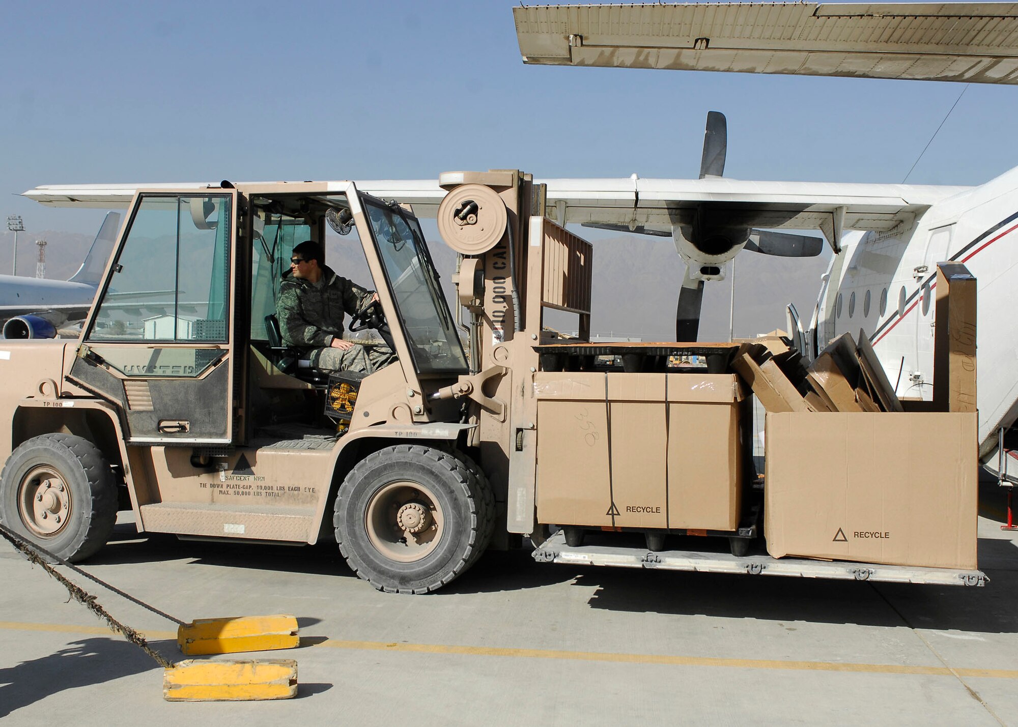 BAGRAM AIRFIELD, Afghanistan -- Senior Airman Eric Smith, an air transportation craftsman from the short take off and landing office of the 455th Expeditionary Aerial Port Squadron, transports boxes of mail to and from the aircraft Nov. 15, 2009.  The STOL office is in charge of delivering personnel and mail to different forward operating bases.  Airman Smith is deployed from McGuire Air Force Base, N.J., and hails from Bossier City, La.  (U.S. Air Force photo/Senior Airman Felicia Juenke)