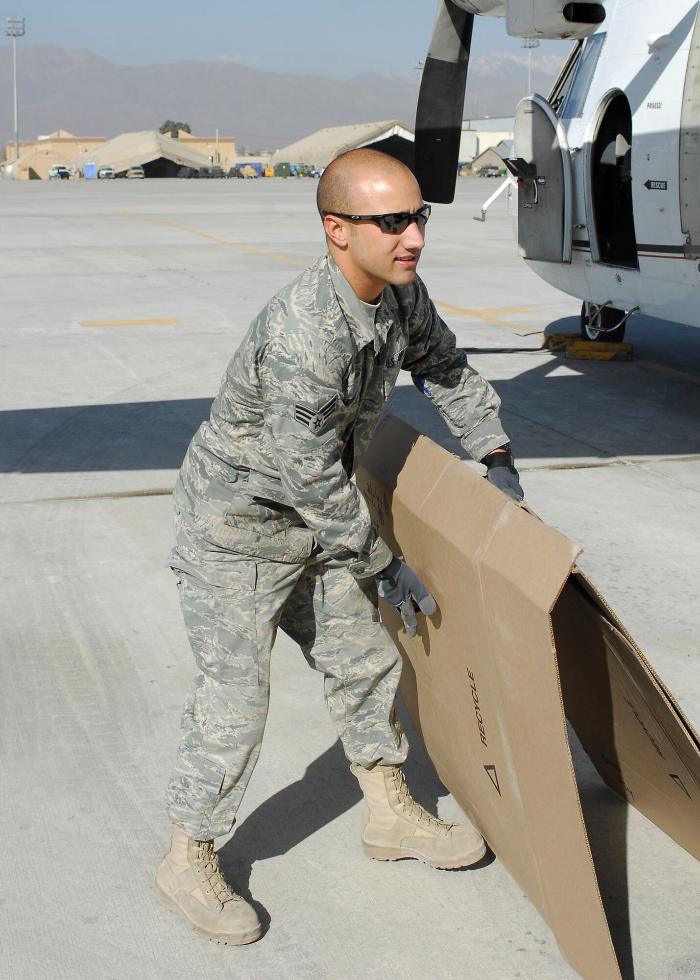 BAGRAM AIRFIELD, Afghanistan -- Senior Airman Joshua Shaffer, an air transportation craftsman from the short take off and landing office of the 455th Expeditionary Aerial Port Squadron, gathers parts of the box used to hold mail Nov. 15, 2009.  The STOL office is in charge of delivering personnel and mail to different forward operating bases.  Airman Shaffer is deployed from the Youngstown Air Reserve Station, Ohio and hails from Warren, Ohio.  (U.S. Air Force photo/Senior Airman Felicia Juenke)