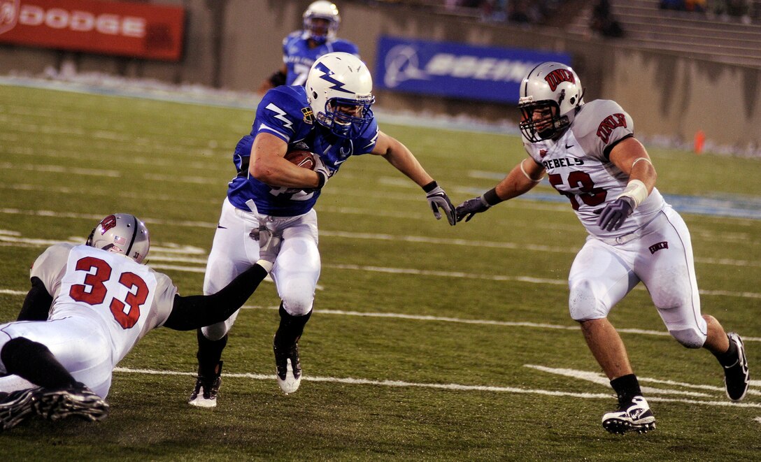 Falcons sophomore running back Jared Tew runs between Rebels linebackers Jason Beauchamp and Matt Kravetz during the Air Force-UNLV at Falcon Stadium Nov. 14, 2009. Tew, a native of Park City, Utah, rushed for 61 yards on 13 carries. The Falcons produced 431 yards on the ground and 557 total yards. (U.S. Air Force photo/Johnny Wilson)
