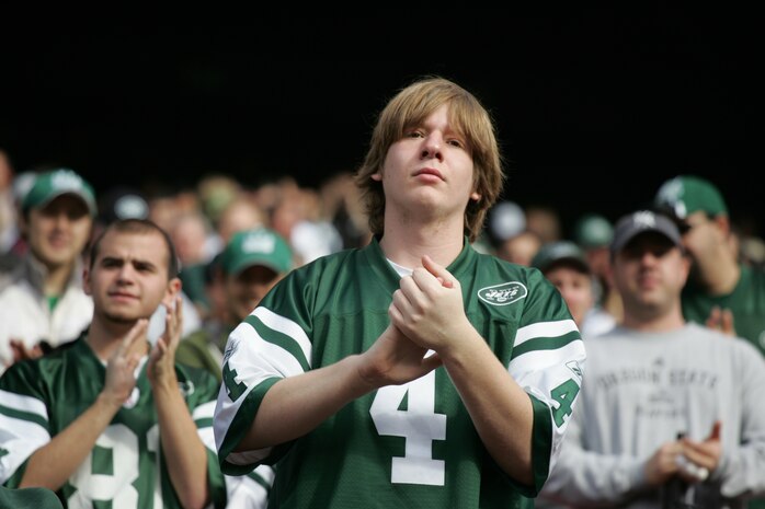 EAST RUTHERFORD, N.J. -- A New York Jets fan cheers on Marine Corps, Air Force, Navy, Coast Guard and Army service members as they march on field at Giants Stadium for a pre-game ceremony honoring veterans, Nov. 15. A Coast Guard detachment sang the National Anthem and were joined by a joint-service color guard before the New York Jets game against the Jacksonville Jaguars. Chief Master Sgt. James A. Roy, Chief Master Sergeant of the Air Force, presented the coin for the pre-game coin toss.(Official Marine Corps photo by Sgt. Randall A. Clinton)