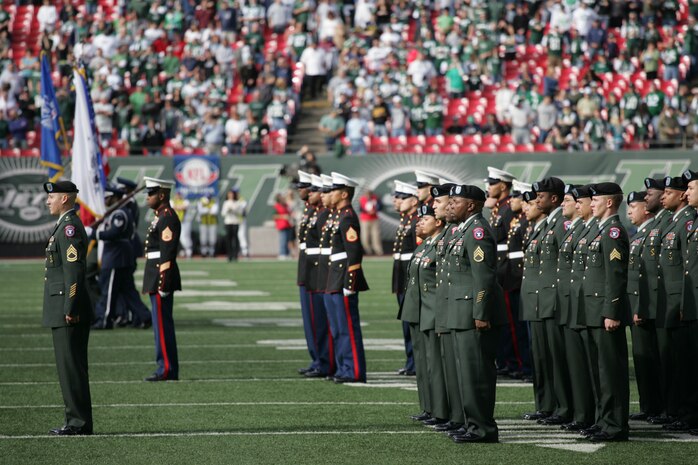EAST RUTHERFORD, N.J. -- Marine Corps, Air Force, Navy, Coast Guard and Army service members stand at attention and salute during the singing of the National Anthem on the field at Giants Stadium for a pre-game ceremony honoring veterans, Nov. 15. A Coast Guard detachment sang the National Anthem and were joined by a joint-service color guard before the New York Jets game against the Jacksonville Jaguars. Chief Master Sgt. James A. Roy, Chief Master Sergeant of the Air Force, presented the coin for the pre-game coin toss.(Official Marine Corps photo by Sgt. Randall A. Clinton)
