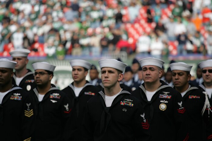 EAST RUTHERFORD, N.J. -- Marine Corps, Air Force, Navy, Coast Guard and Army service members stand at attention and salute during the singing of the National Anthem on the field at Giants Stadium for a pre-game ceremony honoring veterans, Nov. 15. A Coast Guard detachment sang the National Anthem and were joined by a joint-service color guard before the New York Jets game against the Jacksonville Jaguars. Chief Master Sgt. James A. Roy, Chief Master Sergeant of the Air Force, presented the coin for the pre-game coin toss.(Official Marine Corps photo by Sgt. Randall A. Clinton)
