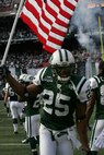 EAST RUTHERFORD, N.J. -- Kerry Rhodes #25, free safety, New York Jets, carrys an American Flag on field during pre-game introduction, Nov. 15. Marine Corps, Air Force, Navy, Coast Guard and Army service members participated in a tribute to veterans before the game. A Coast Guard detachment sang the National Anthem and were joined by a joint-service color guard before the New York Jets game against the Jacksonville Jaguars. Chief Master Sgt. James A. Roy, Chief Master Sergeant of the Air Force, presented the coin for the pre-game coin toss.(Official Marine Corps photo by Sgt. Randall A. Clinton)