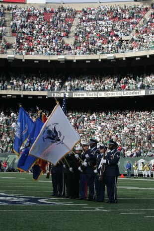 EAST RUTHERFORD, N.J. -- Marine Corps, Air Force, Navy, Coast Guard and Army service members stand at attention and salute during the singing of the National Anthem on the field at Giants Stadium for a pre-game ceremony honoring veterans, Nov. 15. A Coast Guard detachment sang the National Anthem and were joined by a joint-service color guard before the New York Jets game against the Jacksonville Jaguars. Chief Master Sgt. James A. Roy, Chief Master Sergeant of the Air Force, presented the coin for the pre-game coin toss.(Official Marine Corps photo by Sgt. Randall A. Clinton)
