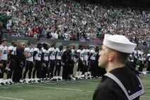 EAST RUTHERFORD, N.J. -- Marine Corps, Air Force, Navy, Coast Guard and Army service members stand at attention and salute during the singing of the National Anthem on the field at Giants Stadium for a pre-game ceremony honoring veterans, Nov. 15. A Coast Guard detachment sang the National Anthem and were joined by a joint-service color guard before the New York Jets game against the Jacksonville Jaguars. Chief Master Sgt. James A. Roy, Chief Master Sergeant of the Air Force, presented the coin for the pre-game coin toss.(Official Marine Corps photo by Sgt. Randall A. Clinton)