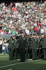 EAST RUTHERFORD, N.J. -- Marine Corps, Air Force, Navy, Coast Guard and Army service members stand at attention and salute during the singing of the National Anthem on the field at Giants Stadium for a pre-game ceremony honoring veterans, Nov. 15. A Coast Guard detachment sang the National Anthem and were joined by a joint-service color guard before the New York Jets game against the Jacksonville Jaguars. Chief Master Sgt. James A. Roy, Chief Master Sergeant of the Air Force, presented the coin for the pre-game coin toss.(Official Marine Corps photo by Sgt. Randall A. Clinton)