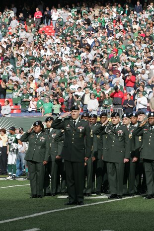 EAST RUTHERFORD, N.J. -- Marine Corps, Air Force, Navy, Coast Guard and Army service members stand at attention and salute during the singing of the National Anthem on the field at Giants Stadium for a pre-game ceremony honoring veterans, Nov. 15. A Coast Guard detachment sang the National Anthem and were joined by a joint-service color guard before the New York Jets game against the Jacksonville Jaguars. Chief Master Sgt. James A. Roy, Chief Master Sergeant of the Air Force, presented the coin for the pre-game coin toss.(Official Marine Corps photo by Sgt. Randall A. Clinton)