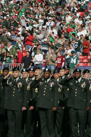 EAST RUTHERFORD, N.J. -- Marine Corps, Air Force, Navy, Coast Guard and Army service members stand at attention and salute during the singing of the National Anthem on the field at Giants Stadium for a pre-game ceremony honoring veterans, Nov. 15. A Coast Guard detachment sang the National Anthem and were joined by a joint-service color guard before the New York Jets game against the Jacksonville Jaguars. Chief Master Sgt. James A. Roy, Chief Master Sergeant of the Air Force, presented the coin for the pre-game coin toss.(Official Marine Corps photo by Sgt. Randall A. Clinton)