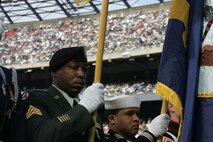 EAST RUTHERFORD, N.J. -- Marine Corps, Air Force, Navy, Coast Guard and Army service members march off to the field at Giants Stadium for a pre-game ceremony honoring veterans, Nov. 15. A Coast Guard detachment sang the National Anthem and were joined by a joint-service color guard before the New York Jets game against the Jacksonville Jaguars. Chief Master Sgt. James A. Roy, Chief Master Sergeant of the Air Force, presented the coin for the pre-game coin toss.(Official Marine Corps photo by Sgt. Randall A. Clinton)