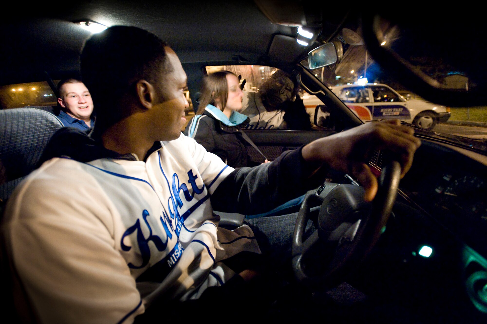 MISAWA AIR BASE, Japan -- Airman 1st Class Mario Hill, Monkeys Against Drunk Driving driver, prepares to drive Navy Petty Officer 3rd Class Megan Flores and Airman 1st Class Brendan Cruz to their homes. M.A.D.D. monkey Airman 1st Class Oscar Jimenez-Manzanares waves at them from the window in the Base Exchange parking lot Nov. 15. Members of M.A.D.D. provided rides for 114 people that night. M.A.D.D. regularly sets up its tent in the Base Exchange parking lot and has given 675 people safe rides home since they started Aug. 8. (U.S. Air Force photo/Staff Sgt. Samuel Morse)