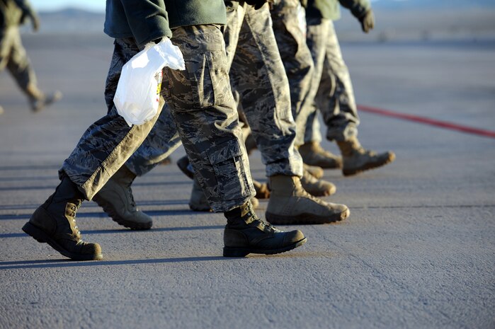 NELLIS AIR FORCE BASE, Nev. -- Nellis Airmen walk across the flightline to perform a foreign object debris walk following the 2009 Aviation Nation Nellis open house, Nov. 16. FOD prevention is every individual's responsibilities as it can cost millions of dollars, and cause damage to aircraft systems or weapons or injury to personnel. (U.S. Air Force photo by Airman 1st Class Brett Clashman)