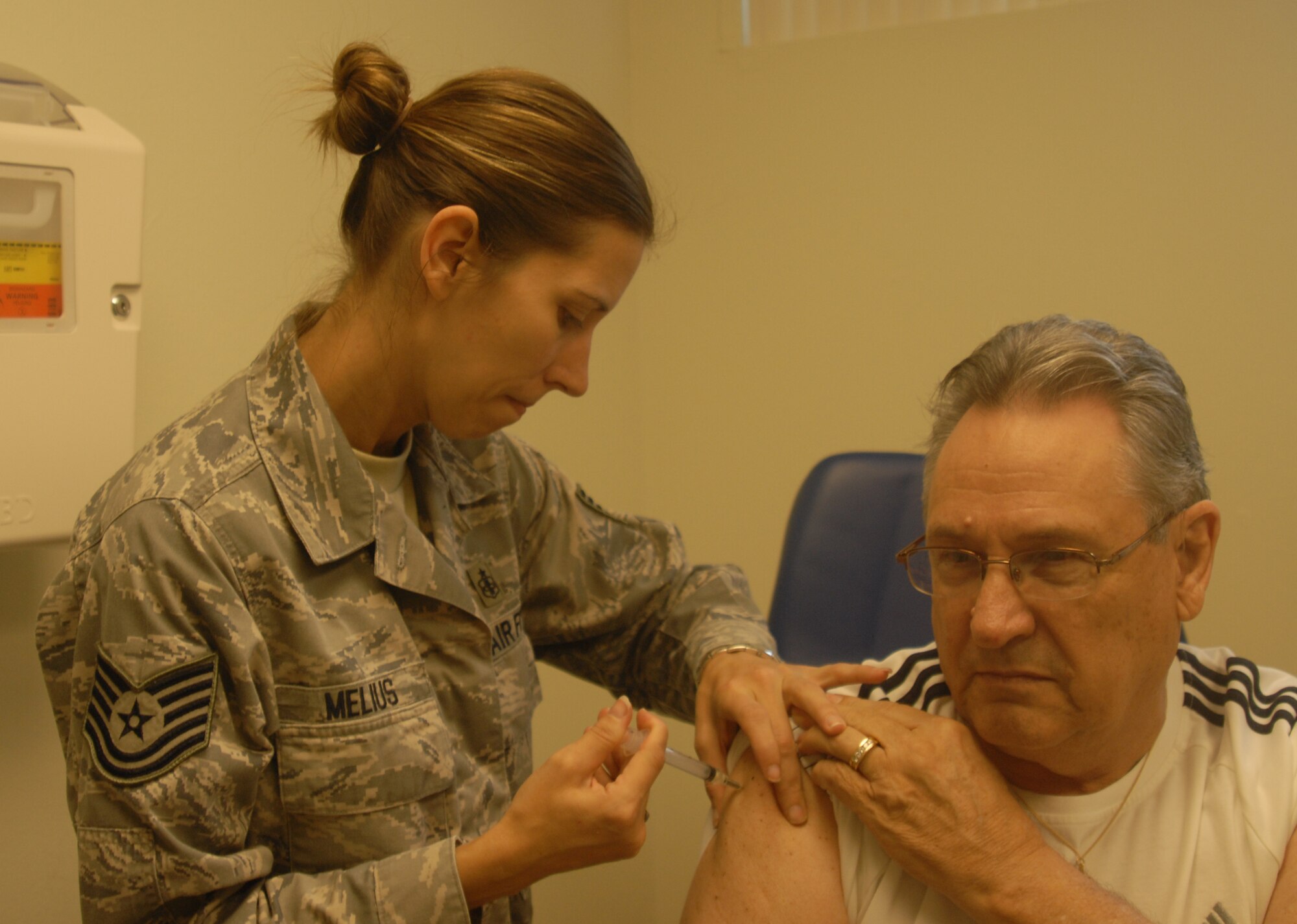 Technical Sgt. Nicole Melius, 17th Medical Group, Noncommissioned Officer in Charge allergy and immunization clinic , gives Retired Air Force Master Sgt. Felix Lisewsky a flu shot during the Goodfellow Military Retirees Appreciation Day and Health Fair, Nov. 14 at the Goodfellow clinic. ( U.S. Air Force photo/Airman 1st Class Anne Gathua)