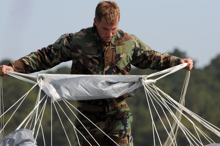 MOODY AIR FORCE BASE, Ga. -- Capt. Brent McCall, 38th Rescue Squadron combat rescue officer, ties suspension lines together on his parachute after a free-fall jump here Oct. 29. Tying the suspension lines makes transporting the parachute easier. (U.S. Air Force photo by Staff Sgt. Elizabeth Rissmiller)