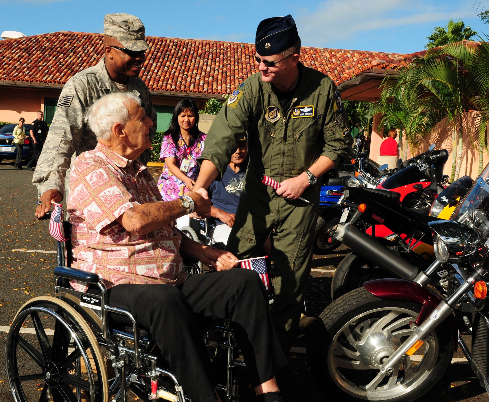 Lt. Col. Michael Benham, the 13th Air Force chief of safety, greets a veteran from Tripler Army Medical Center's Community Living Center in Honolulu, Hawaii during a visit by the Hickam Green Knights Motorcycle club on Veterans Day, Nov. 11. The group spent time handing out commemorative U.S. flags that reflect the spirit of Veterans Day. The bikers also helped the veterans move about the center and took them outside for a quick view of their bikes which filled a large portion of the parking lot. (Air Force photo /Tech. Sgt. Kerry Jackson) 