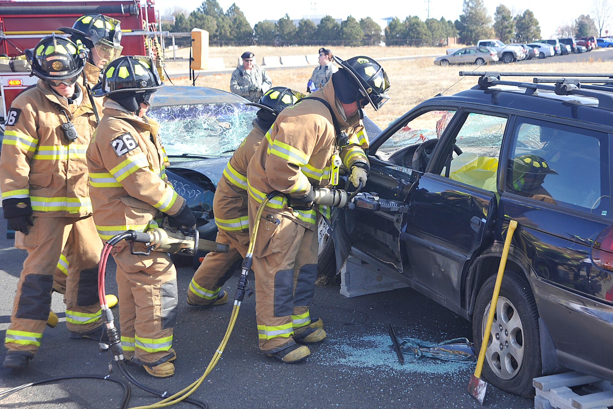 21st Space Wing firefighters use a hydraulic rescue tool, also known as the “jaws of life,” to peel back the metal of a smashed car door so they could safely extract an injured driver. Firefighters and rescue workers were on the scene of a simulated drunk driving crash Nov. 10 on Peterson Air Force Base. The event, Every 15 Minutes, was hosted by U.S. Northern Command and included participation from the 21st Space Wing's firefighters, security forces and emergency medical teams. The anti-drug event is meant to leave a visual image that will deter Airmen from drinking and driving, event organizers said. (Air Force photo by Dennis Howk)


