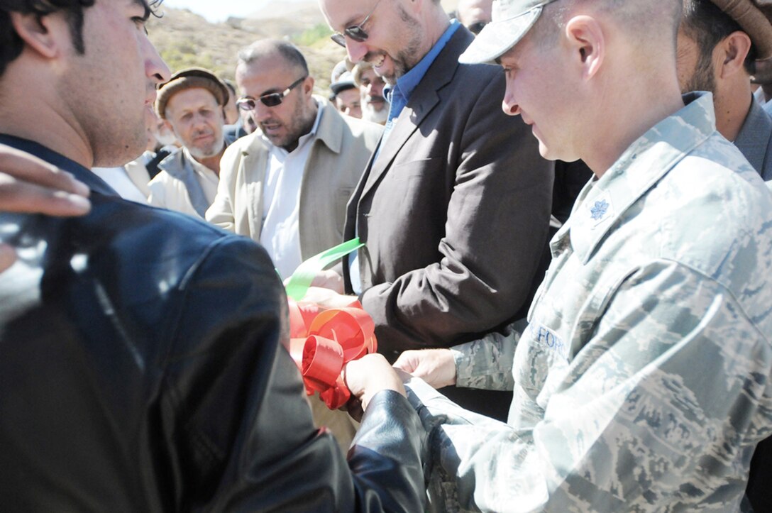 Lt. Col. Eric Hommel (right) and James DeHart (second from right) join Panjshir Governor Hajji Bahlol in a ribbon cutting ceremony officially opening Khermensan Road Oct. 8, 2009, in the Anaba district of the Panjshir Province, Afghanistan. Civilian-military integration is vital in the reconstruction efforts in the Panjshir valley. Colonel Hommel is the Panjshir Provincial Reconstruction Team commander, and Mr. DeHart is the PRT director. (U.S. Air Force photo/Capt. John Stamm)