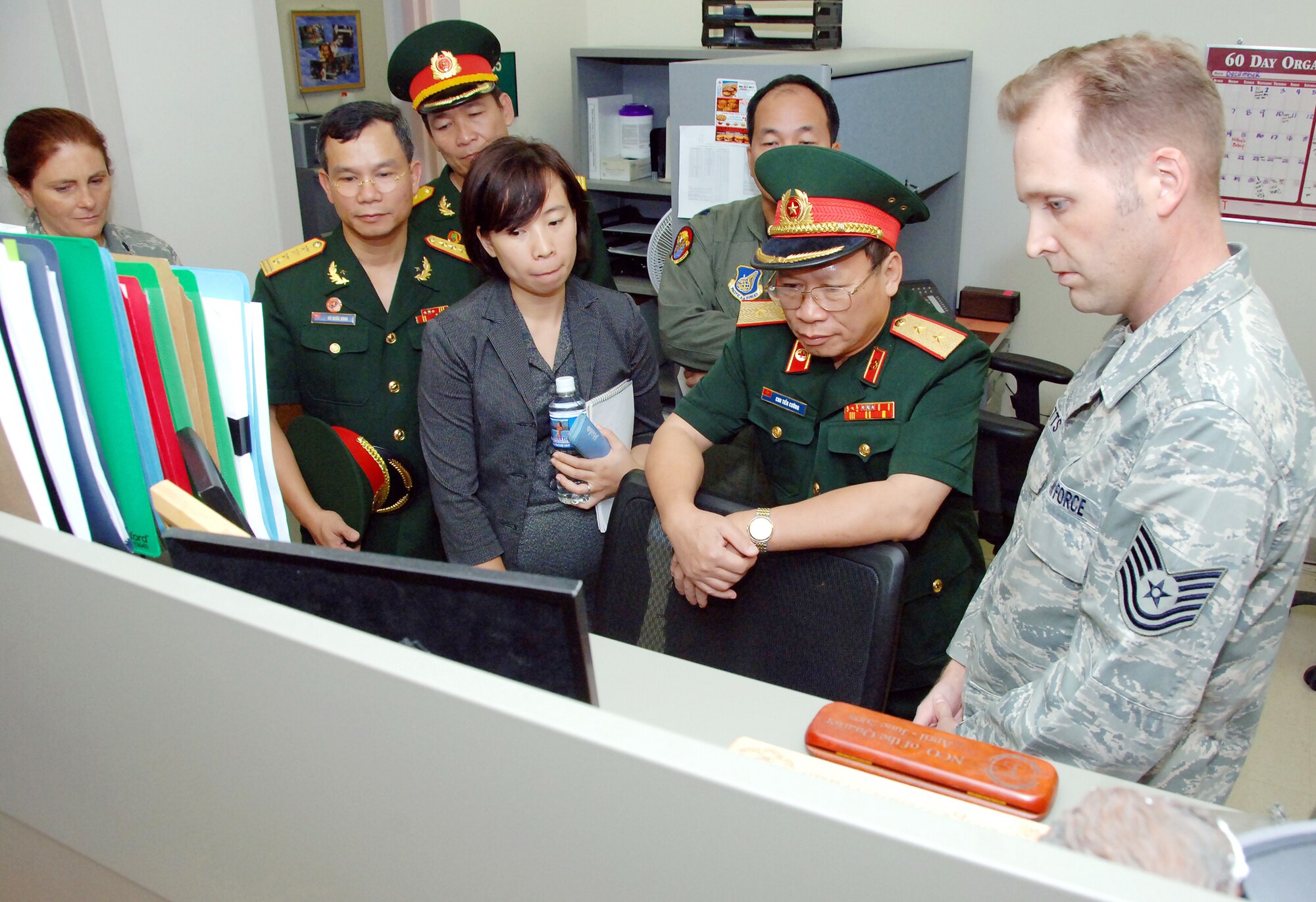 Tech. Sgt. Brian Watts explains to Lt. Gen. Chu, Tien Cuong, director of the Vietnam Military Medical Department, how the U.S. Air Force uses a database to track individual medical readiness during the general's visit to Hickam Air Force Base, Hawaii, Nov. 10, 2009. Six delegates from the Vietnam military health and general logistics fields met with U.S. Air Force officials at Hickam during a 13th Air Force-hosted visit. The delegates learned how the U.S. military conducts surveillance, screening and testing of infectious diseases, and how the U.S. Air Force plans and conducts logistics operations. Sergeant Watts is a public health craftsman in the 15th Aeromedical Dental Squadron. (U.S. Air Force photo/Vanessa Forloine)