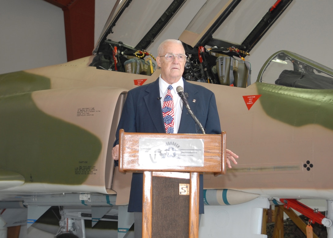 Retired Air Force Col. James Hivner addresses an audience of family, friends and more than 50 Sheppard Air Force Base personnel Nov. 11 at the Cavanaugh Flight Museum in Addison, Texas. The museum and Sheppard hosted a ceremony for the colonel and his wife, Phyllis, to return his wedding ring and dog tag. The items were confiscated Oct. 5, 1965, after his F-4C Phantom, much like the aircraft in the background, was shot down over North Vietnam. (U.S. Air Force photo/Lou Anne Sledge)