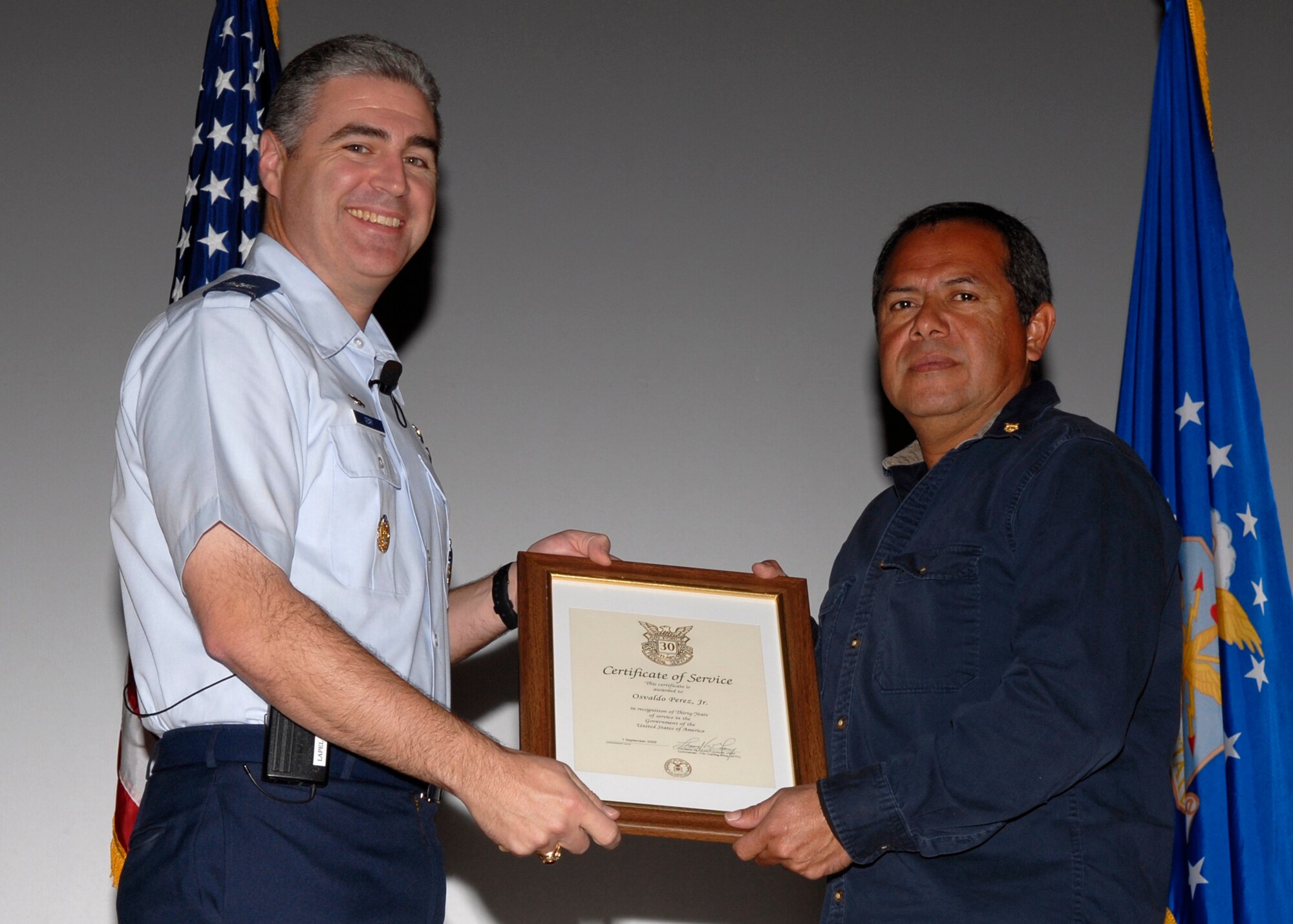 Col. Tom Geary, 17th Training Wing commander, Goodfellow AFB, Texas presents Mr. Osvaldo Perez Jr. from the 17th Logistics Readiness Squadron, a certificate of recognition for thirty years of civil service on Nov. 5 during the a quarterly wing commander's call.  ((U.S. Air Force photo/Lou Czarnecki)