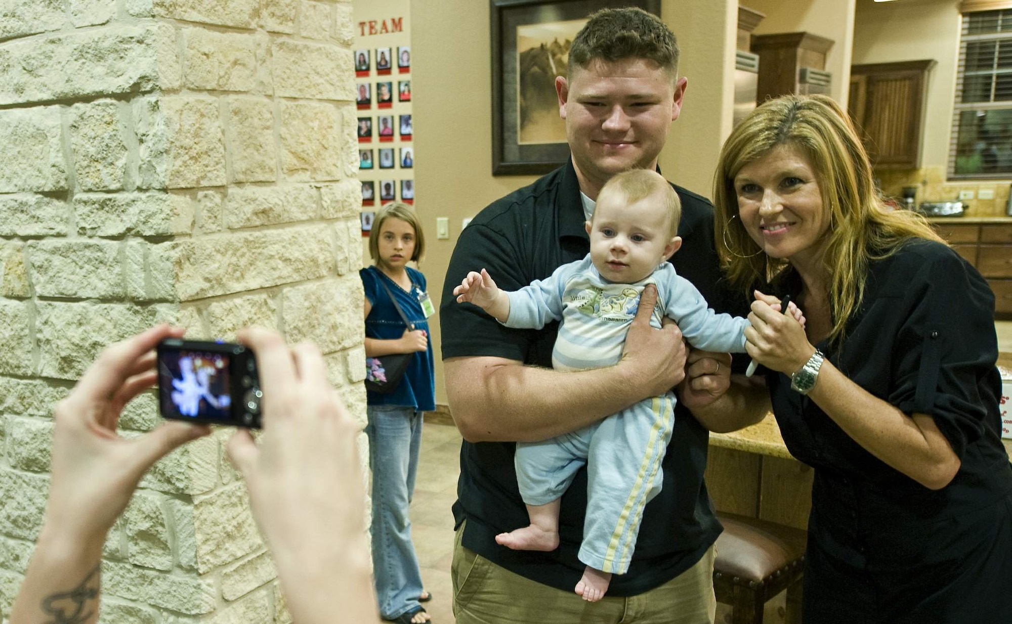 "Friday Night Lights" actress Connie Britton poses for a photo with a U.S. servicemember and his child Nov. 14, 2009, at the Warrior and Family Support Center on Fort Sam Houston, Texas. (U.S. Air Force photo/Staff Sgt. Bennie Davis)