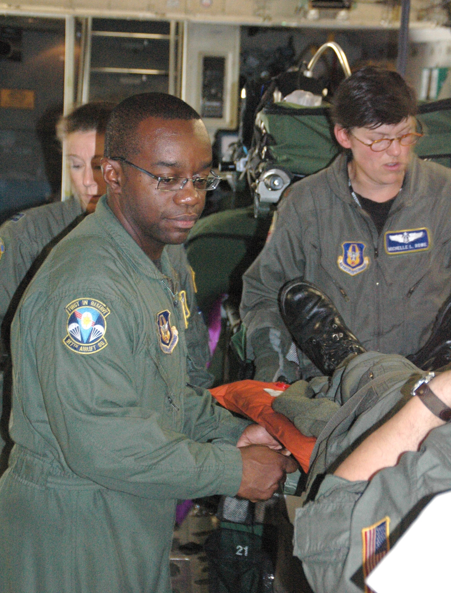 Master Sgt. Reggie Godbolt (left), a loadmaster with the 317th Airlift Squadron, Charleston AFB, S.C., helps Maj. Michelle Rowe, flight nurse with the 439th Aeromedical Evacuation Squadron, Westover ARB, Mass., secure a simulated patient on a joint C-17 training mission.  (Air Force photo/Capt. Wayne Capps)
