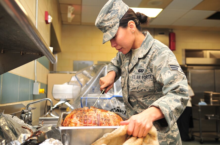 Senior Airman Jai Kang, 4th Force Support Squadron food service journeyman, slices ham at the Southern Eagles Dinning Facility on Seymour Johnson Air Force Base, N.C., Nov. 10, 2009. All large meats are cut open before being served to check the internal temperature ensuring it is safe to eat.  Airman Kang is originally from Ft. Walton Beach, Fla. (U.S. Air Force Photo/Airman 1st Class Rae Perry)