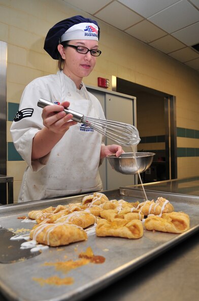 Senior Airman Jourdan McManus, 4th Force Support Squadron food service journeyman, prepares an apple desert at the Southern Eagles Dining Facility on Seymour Johnson Air Force Base, N.C., Nov. 10, 2009. The DFAC is open year round to provide food for base Airmen, retirees and civilian employees. Airman McManus is originally from Decatur, Ill. (U.S. Air Force Photo/Airman 1st Class Rae Perry)