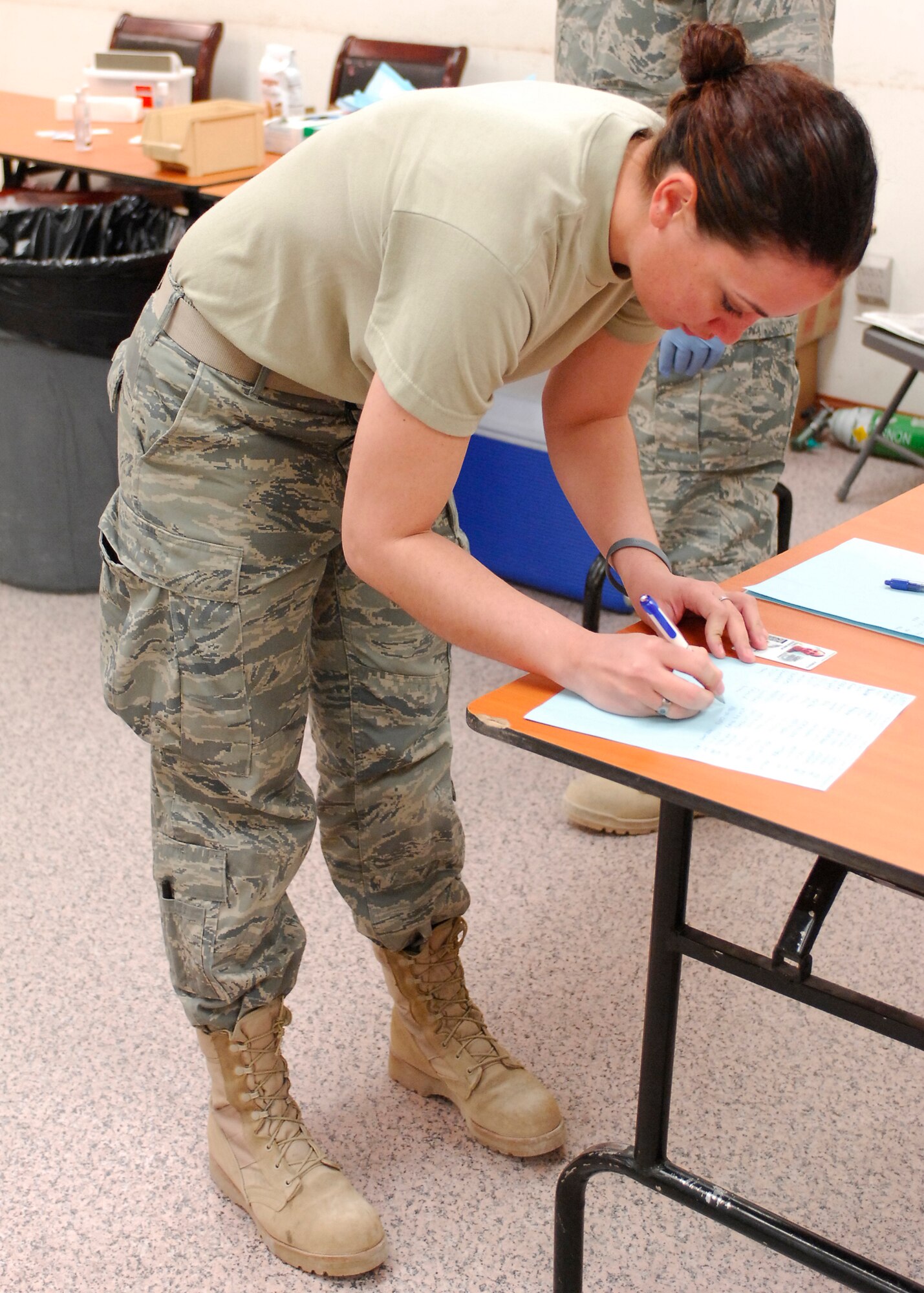 BAGRAM AIRFIELD, Afghanistan -- Senior Airman Susan Tracy, a videographer from the 455th Air Expeditionary Wing, signs in to validate she received her Influenza A 2009 (H1N1) monovalent vaccine Nov. 16, 2009.   Airman Tracy is deployed from Dyess Air Force Base, Texas and hails from Elk Grove, Calif.  (U.S. Air Force photo/Senior Airman Felicia Juenke)