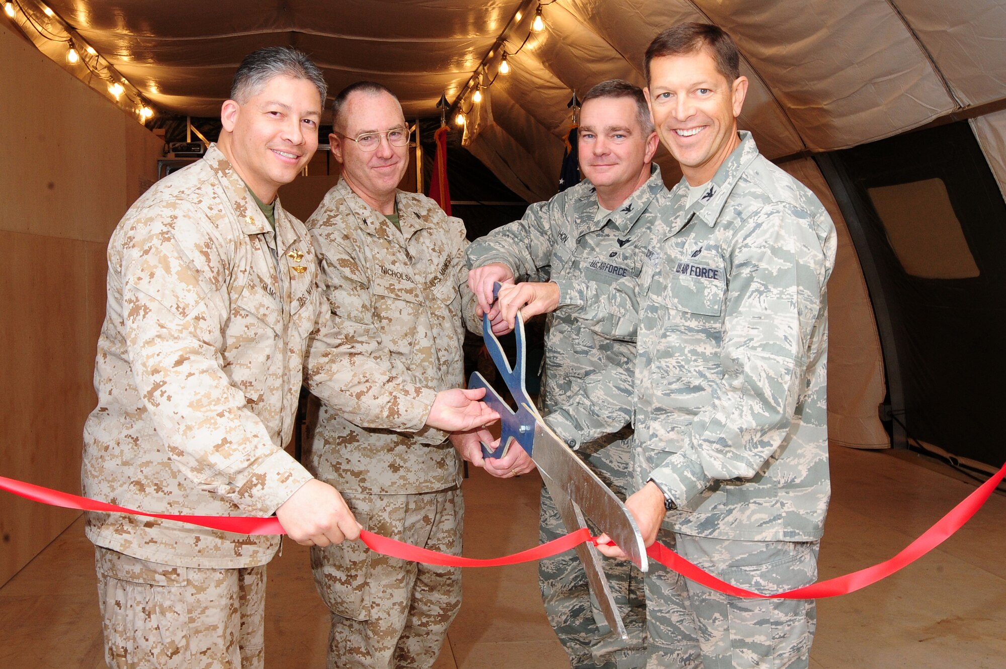 TRANSIT CENTER AT MANAS, Kyrgyzstan -- Lt. Cmdr. Orlando Olmo, Col. John Nicholson, Col. Michael Mahon, and Col. Thomas Joyce, cut the ribbon at the Marines Customs Tent, Nov. 6, 2009. The customs facility will be used as a 100-percent checkpoint for all Marines re-deploying to their home station. (U.S. Air Force photo/Senior Airman Steele C. G. Britton)