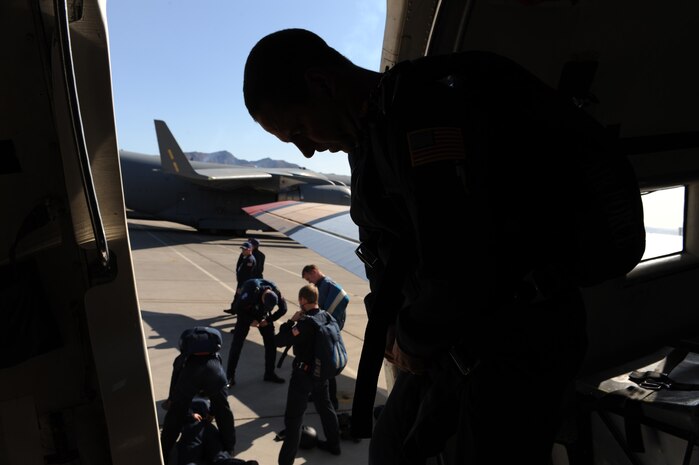 NELLIS AIR FORCE BASE, Nev.-- Master Sgt. David Fremin, a U.S. Air Force Academy Parachute Team "Wings of Blue" instructor, is silhouetted in the doorway of their jump plane while the combined cadet, instructor demonstration team perform pre-jump checks at the Aviation Nation Nellis Open House Nov. 14. The open house is an opportunity for the Las Vegas community to view aerial demonstrations and static displays of various aircraft from the military. The open house also acts as the final air show of the year for the U.S. Air Force Air Demonstration Squadron Thunderbirds. (U.S. Air Force photo by Tech. Sgt. Michael R. Holzworth)