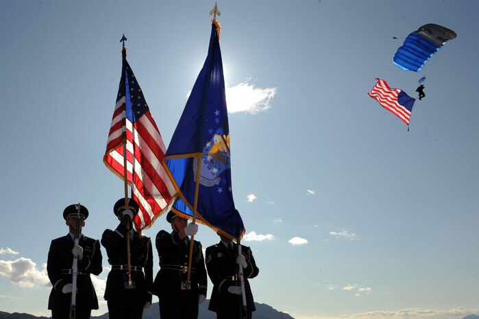 NELLIS AIR FORCE BASE, Nev.-- The Nellis Honor Guard present the colors while a member of the U.S. Air Force Academy Parachute Team displays the American flag during the opening ceremony of the 2009 Aviation Nation Nellis Open House. The open house is an opportunity for the Las Vegas community to view aerial demonstrations and static displays of various aircraft from the military. The open house also acts as the final air show of the year for the U.S. Air Force Air Demonstration Team Thunderbirds. (U.S. Air Force photo by Tech. Sgt. Michael R. Holzworth)