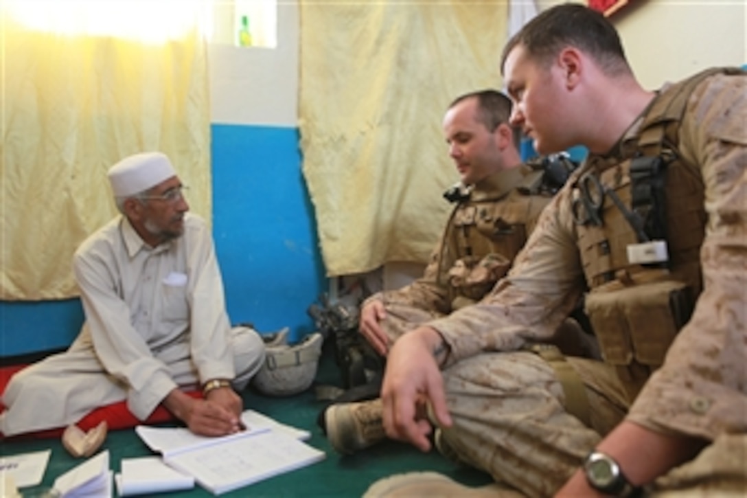 U.S. Navy Chief Petty Officer Anthony Geron (2nd from right) and Petty Officer 3rd Class Matthew Novak, with India Company, 3rd Battalion, 4th Marine Regiment, listen as an Afghan doctor goes over a list of additional supplies after the Marines and corpsmen delivered medical supplies to a clinic in Golestan, Afghanistan, on Nov. 4, 2009.  Marines bring supplies to the clinic to ensure the local population receives medical care when needed.  