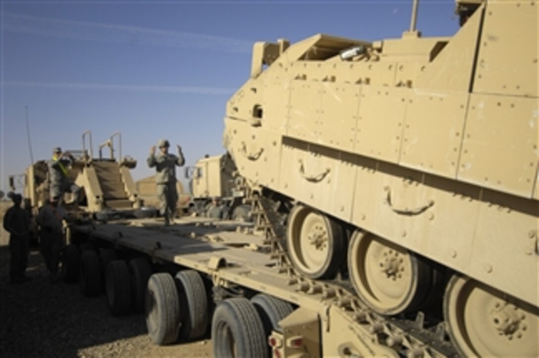 A U.S. Army soldier attached to the 2025th Transportation Company, 15th Sustainment Brigade, 3rd Infantry Division guides an M99282 Carrier Ammo Trailer onto the flatbed trailer of a heavy equipment transport truck at Forward Operating Base Warrior in northern Iraq on Nov. 7, 2009.  