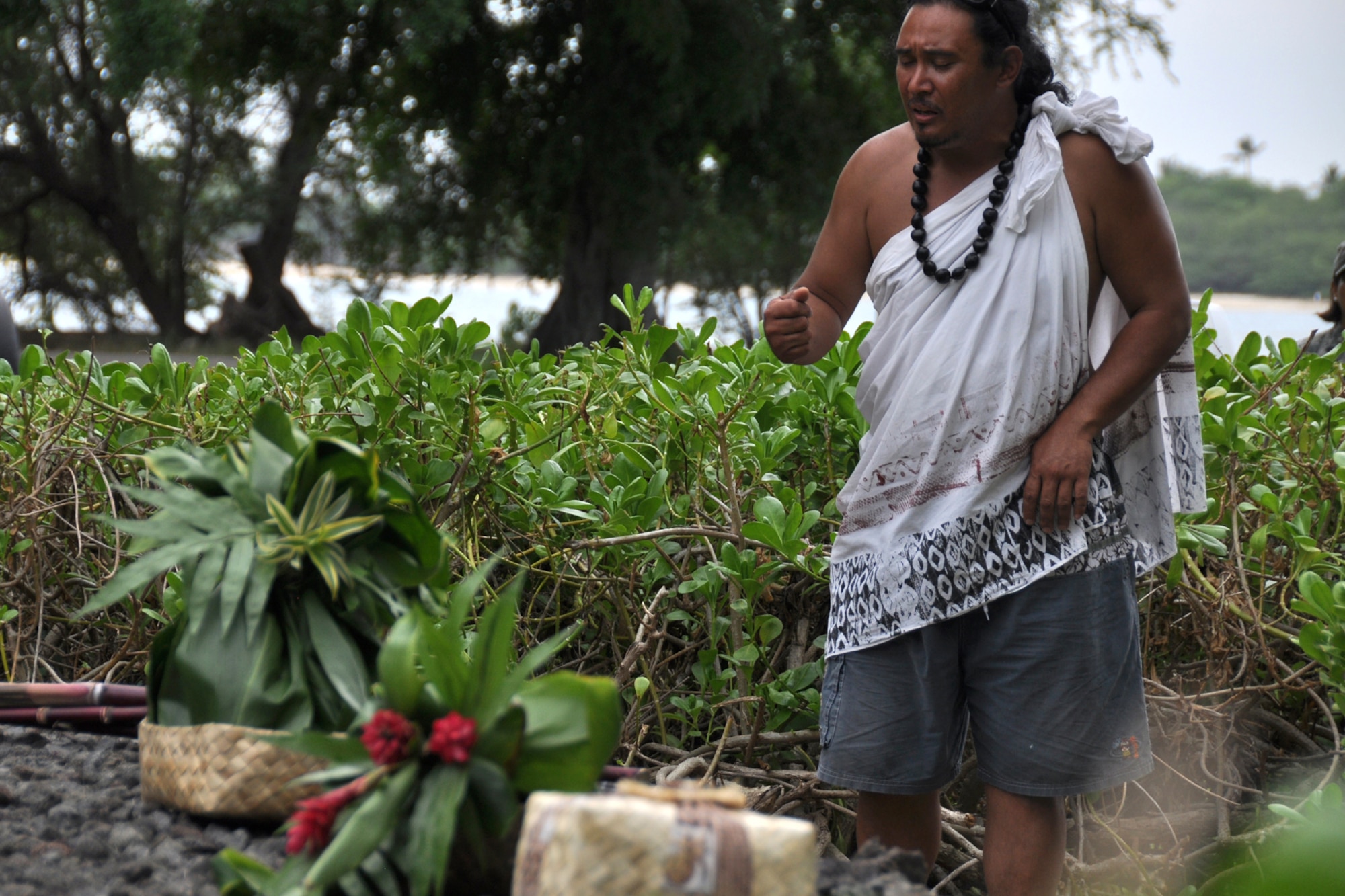 HICKAM AIR FORCE BASE, Hawaii - Braven Canibog, chants an oli, or a blessing, in the native Hawaiian language at the Haleamau Halealoha burial site on Hickam Nov. 14 following the 7th Annual Kapuaikaula (Hickam) Makahiki (Thanksgiving) festival. Local Hawaiian and Hickam officials gathered at Hickam Harbor on Nov. 14 for the Makahiki festival. The festival involved a ceremonial arrival in canoes, spiritual offerings, five skills competitions and a feast to end the day. According to history texts, the Makahiki was started to honor Lono, the Hawaiian guardian of agriculture, rain, health and peace. The offerings to Lono during the Makahiki were taken to the burial site. (DoD photo by U.S.  Air Force Tech Sgt. Cohen A. Young)