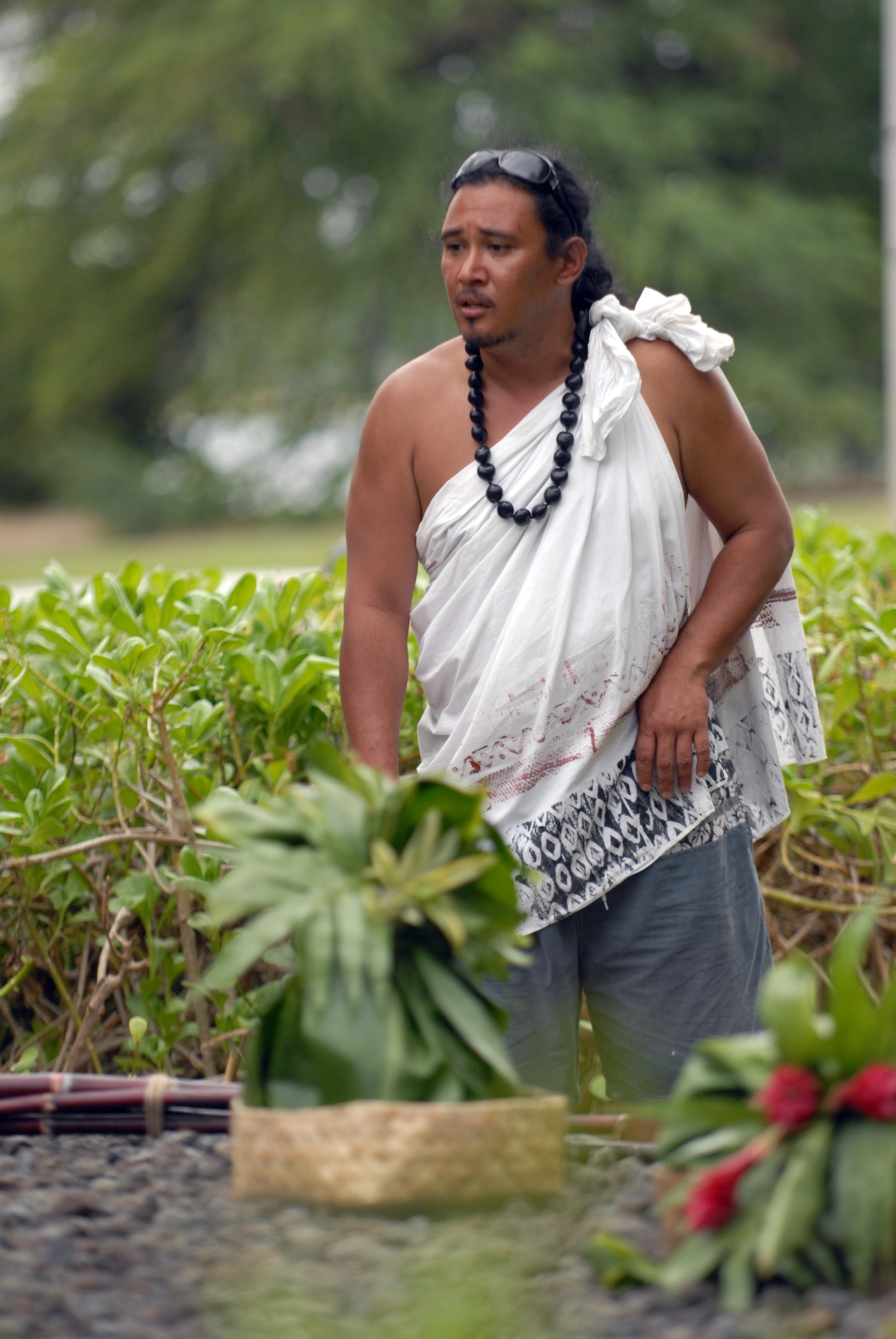 HICKAM AIR FORCE BASE, Hawaii -- Braven Canibog, chants an Oli, or a blessing, in the native Hawaiian language  at the Haleamau Halealoha Burial after the Makahiki Festival here, Nov. 14. The gifts were set on the burial to respect and honor the ancestors of Hawaiians who came before them. (U.S. Air Force photo/Senior Airman Gustavo Gonzalez)