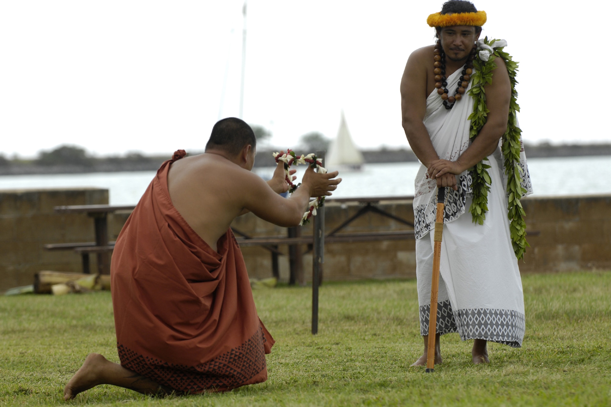 HICKAM AIR FORCE BASE, Hawaii - Braven Canibog, Makahiki protocol officer, watches as Kanoa Nelson offers a lei as an offering to Lono during the 7th Annual Kapuaikaula (Hickam) Makahiki (Thanksgiving) festival Nov. 14. Local Hawaiian and Hickam officials gathered at Hickam Harbor for the ancient ceremony and festival. The festival involved a ceremonial arrival in canoes, spiritual offerings, five skills competitions and a feast to end the day. According to history texts, the Makahiki was started to honor Lono, the Hawaiian guardian of agriculture, rain, health and peace. The offerings to Lono during the Makahiki were taken to the burial site. (DoD photo by U.S.  Air Force Tech Sgt. Cohen A. Young)