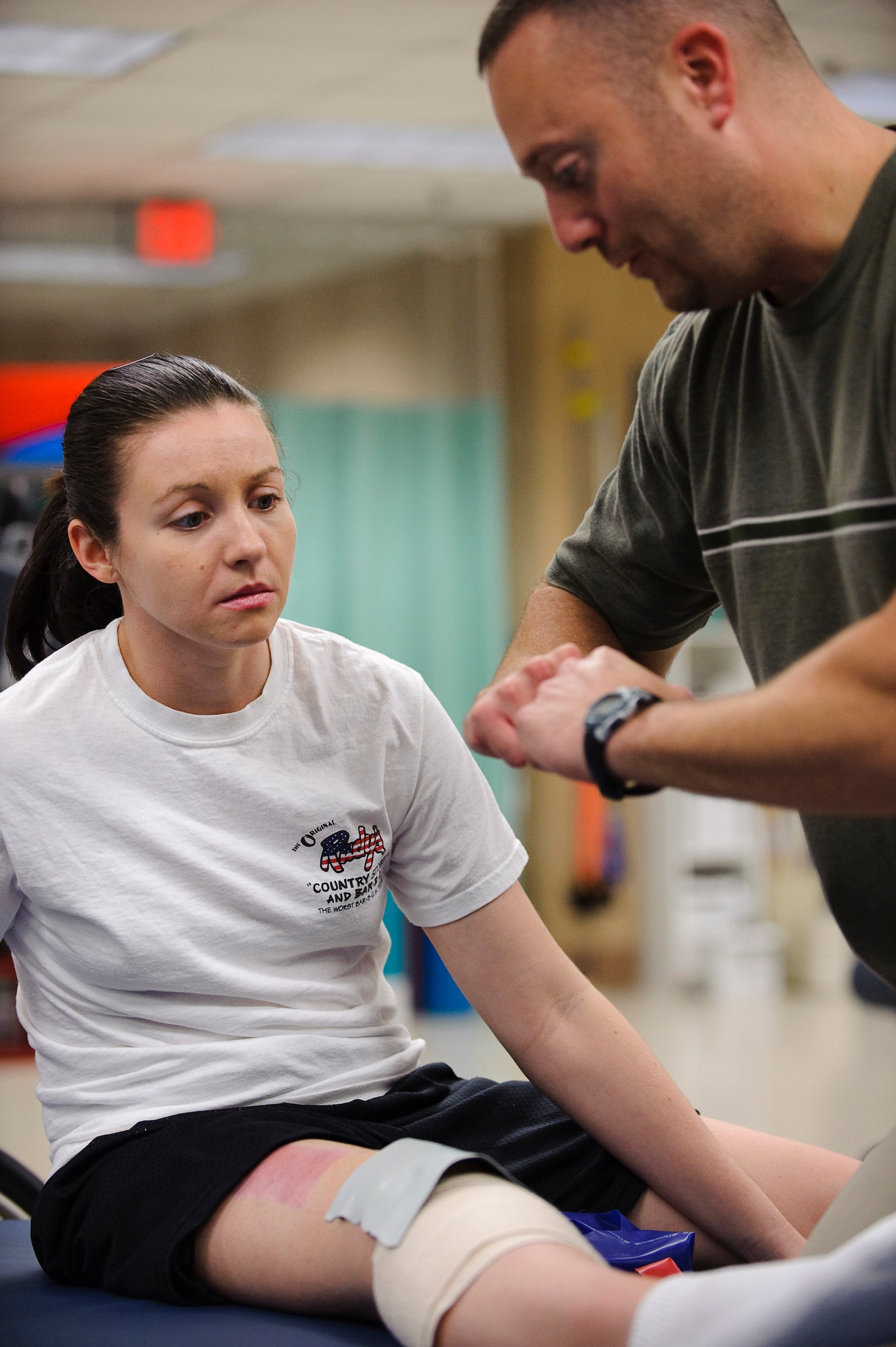 Physical therapy assistant John Inzinna, right, demonstrates the proper function of a knee joint to Capt. Wendy Kosek, 19th Airlift Wing legal officer, during her physical therapy session at Brooke Army Medical Center’s outpatient physical therapy clinic. (U.S. Air Force photo/Steve Thurow)