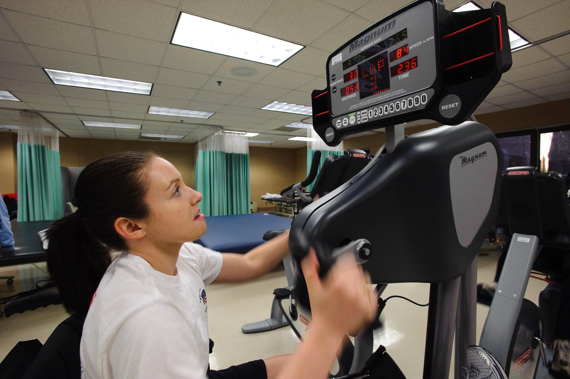 To maintain her aerobic fitness, Capt. Wendy Kosek, a 19th Airlift Wing legal officer at Little Rock Air Force Base, Ark., usually completes six miles on an upper body ergometer for cardio training. Captain Kosek is at Brooke Army Medical Center in San Antonio rehabilitating from injuries sustained in Iraq from a improvised explosive device that struck the convoy she was traveling in. (U.S. Air Force photo/Steve Thurow)