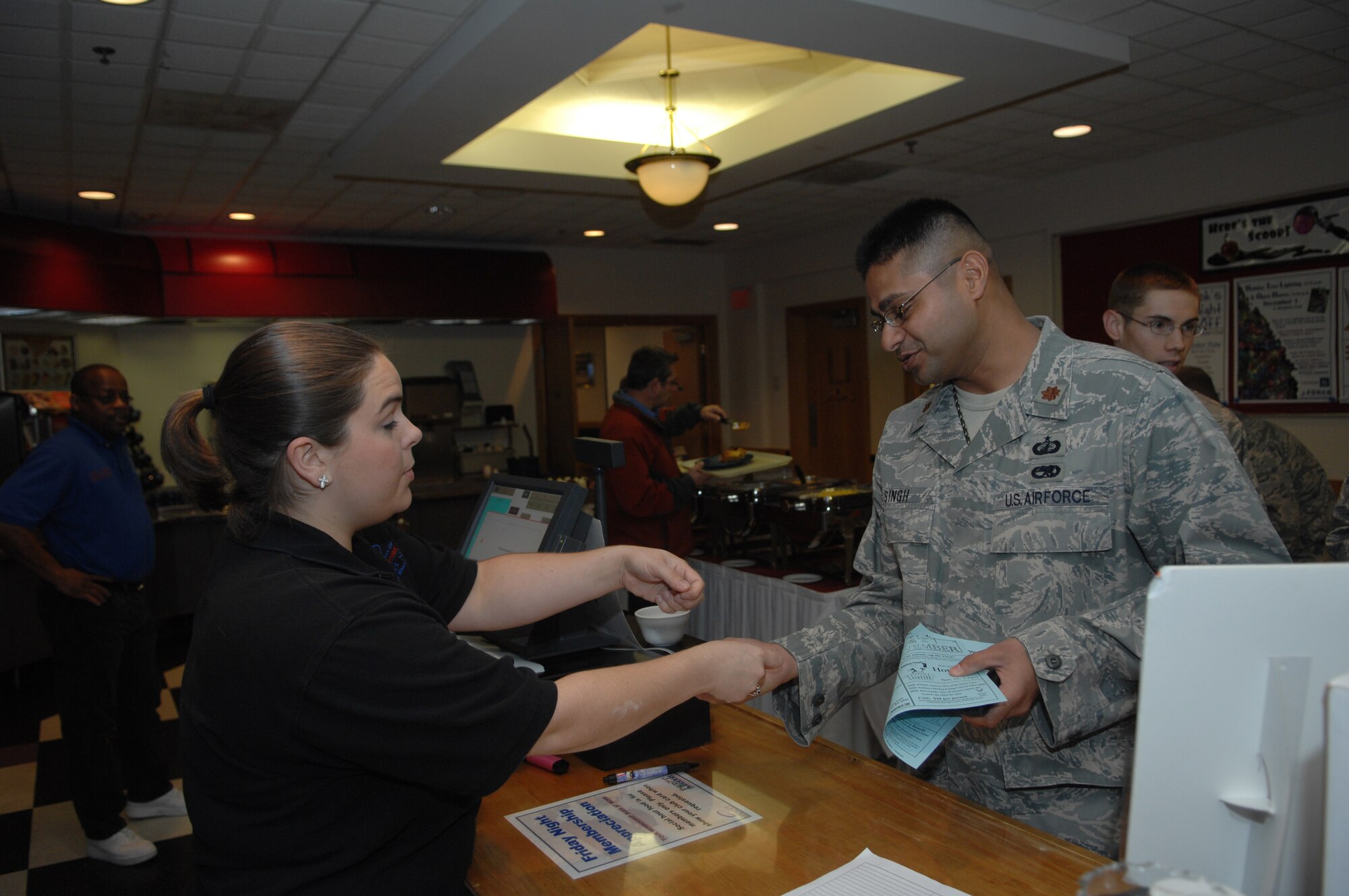 WHITEMAN AIR FORCE BASE Mo. – Krystal Bagget a waitress at Missions End hands change to  Maj.  Sanjit Singh, 509th Contracting Squadron commander, during lunch here Nov.  17.  Missions End offers a variety of catered events during large and small, from wedding receptions to sweet 16 birthday parties and military functions such as Airmen Leadership School graduations.( U.S. Air Force Photo/ Senior Airman Jessica Mae Snow) (Released)