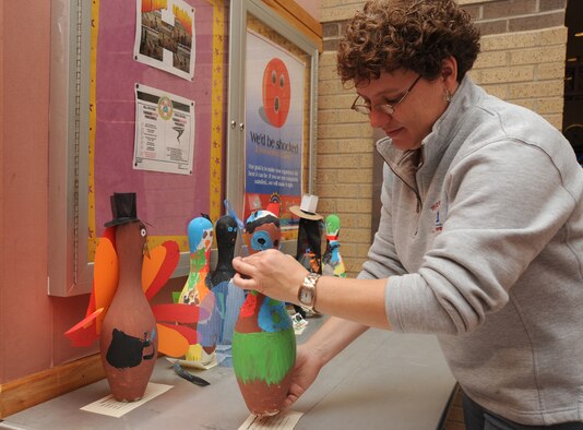 Sharon Bank, a community center assistant from the 22nd Force Support Squadron, places decorated turkey pins on display at the Tornado Alley bowling center, Nov. 16, 2009, at McConnell Air Force Base, Kan. Team McConnell members can vote for their favorite pins. The 22nd Force Support Squadron members will announce winners during Tornado Alley’s annual turkey bowl, Nov. 21. (U.S. Air Force photo/Tech. Sgt. Chyrece Campbell)