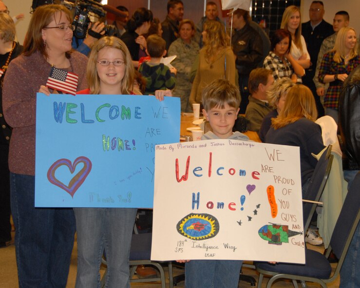 The family of Maj Joe Dessenberger displays “Welcome Home” signs for their dad.  Their dad led the 184 SFS during the 8 month long deployment to Southwest Asia and returned to McConnell AFB, KS on November 16, 2009.