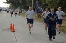 Members of the 1st Combat Camera Squadron  approach the finish line during the Run the Runway 5K event honoring retired Brig. Gen. Thomas Mikolajcik here on Wingman Day Nov. 17. More than 800 Team Charleston members participated in the run which lead through part of the base and onto the runway. (U.S. Air Force photo/Staff Sgt. Marie Brown)
