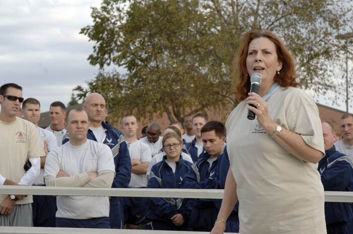 Carmen Mikolajcik gives her welcoming remarks prior to the start of the Run the Runway 5K event honoring retired Brig. Gen. Thomas Mikolajcik here on Wingman Day Nov. 17. General Mikolajcik, who suffers from amyotrophic lateral sclerosis, was unable to attend the event and was represented by his wife Carmen and two of his children. (U.S. Air Force photo/Staff Sgt. Marie Brown)